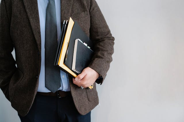 man carrying notebooks