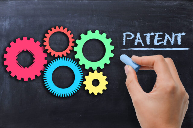 Industrial patent protection concept with gears on blackboard
