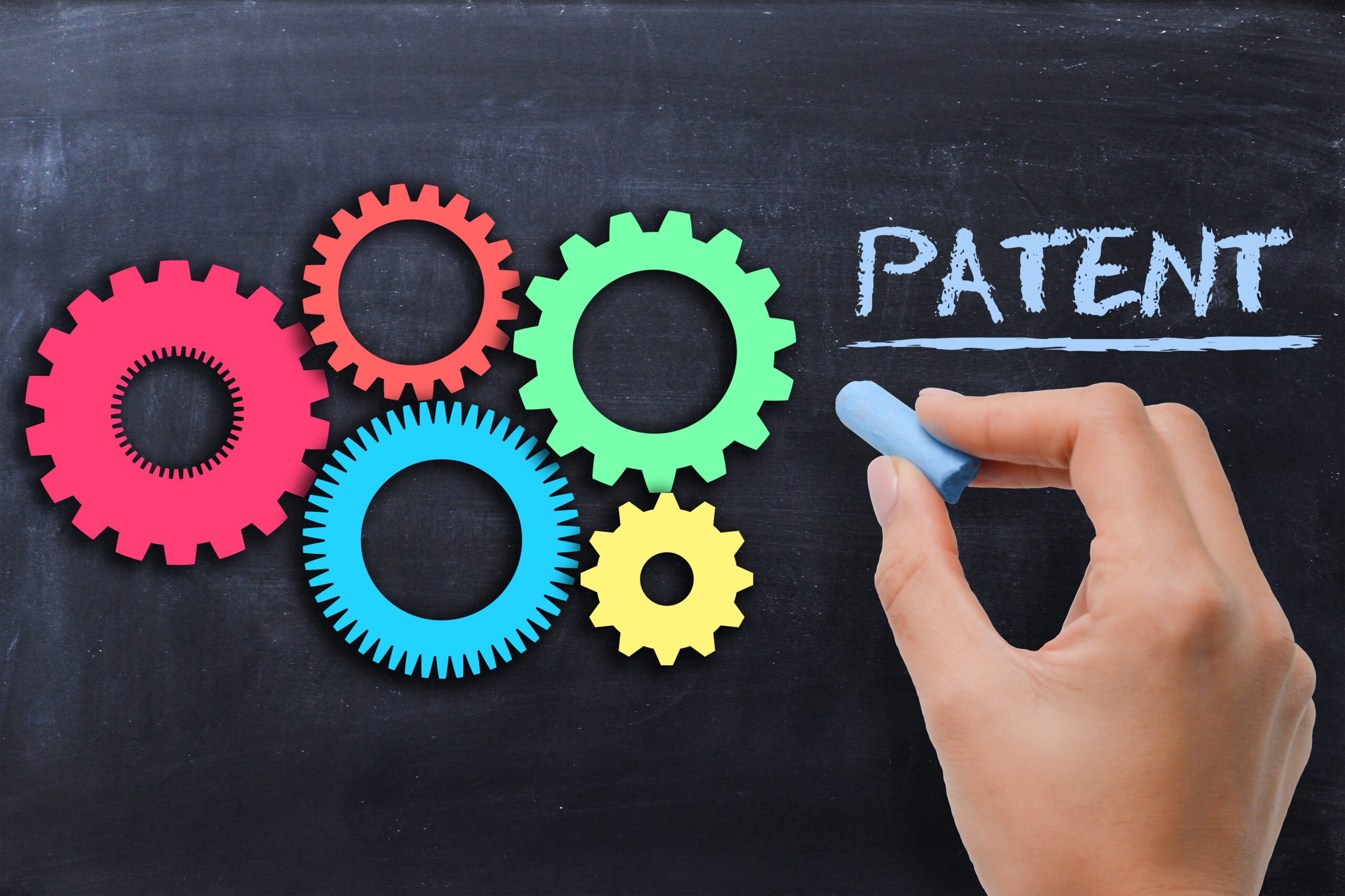 Industrial patent protection concept with gears on blackboard