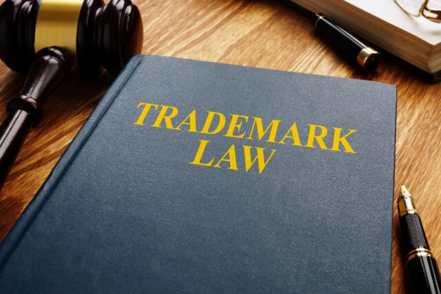 Trademark law and gavel on a wooden surface. Copyright concept.