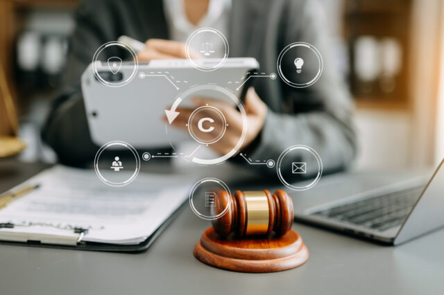 Copyright or patent concept, Person hand using laptop computer, tablet and smartphone with virtual screen copyright icon trademark, Creation ownership against piracy. at office