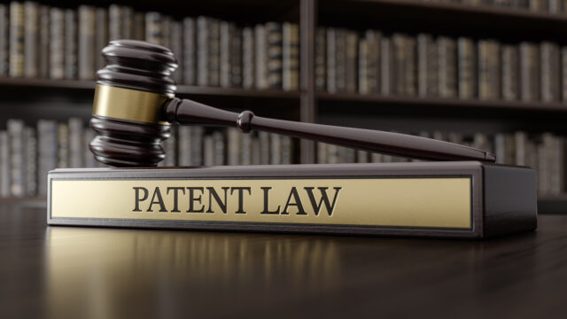 Patent Law: Judge's Gavel as a symbol of legal system and wooden stand with text word.